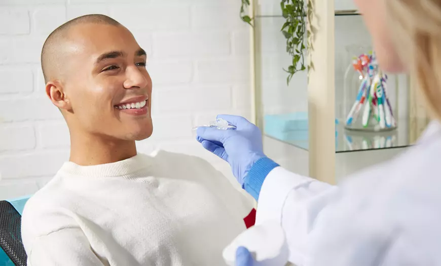 A Patient Smiling at His Biological Dentist While She Is Performing a Functional Dentistry Procedure A Patient Smiling at His Biological Dentist While She Is Performing a Functional Dentistry Procedure
