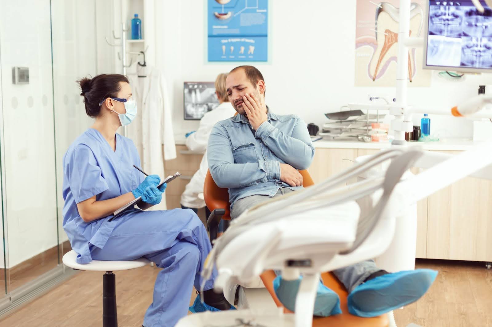 A Dentist Smiling at The Lens While Addressing a TMJ Disorder and Jaw Pain  A Dentist Smiling at The Lens While Addressing a TMJ Disorder and Jaw Pain
