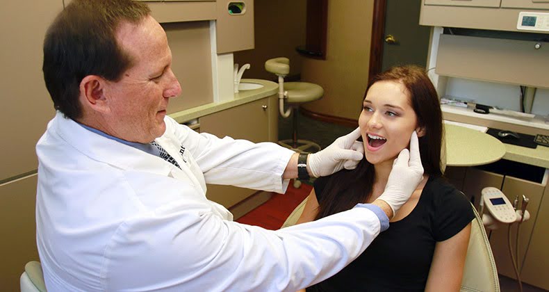 A Dentist Checking Jaw Pain in joints of A girl in the Clinic A Dentist Checking Jaw Pain in joints of A girl in the Clinic